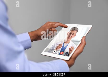 Telemedicine. Man having online consultation with doctor via tablet computer, closeup Stock Photo