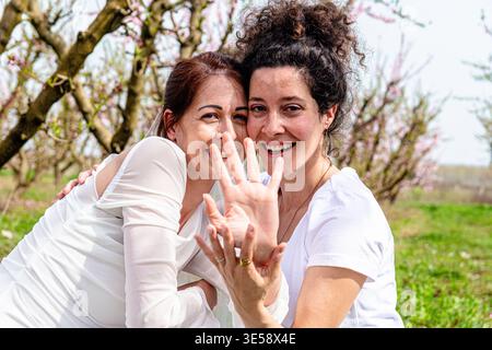 Two women embracing happiness and togetherness in nature Stock Photo