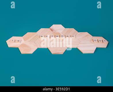 Wooden hexagonal tiles forming a network structure with IN, NETWORK, and OUT words, symbolizing data flow, connectivity, and digital communication sys Stock Photo