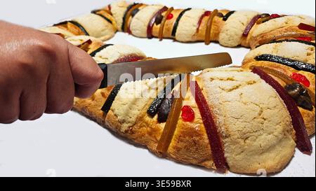 Rosca de Reyes is a traditional sweet bread decorated with crystallized fruits and hidden figures of the baby Jesus, which is shared with family Stock Photo