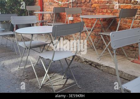Empty tables and chairs set up in a quiet outdoor area Stock Photo