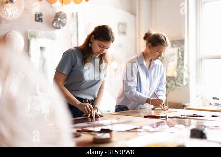 Craftswomen colleagues working in creative glass studio Stock Photo