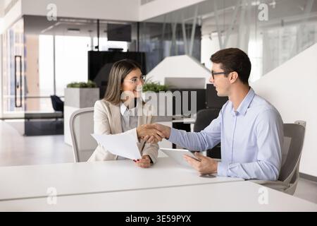 Businesswoman and businessman sealing deal with handshake Stock Photo