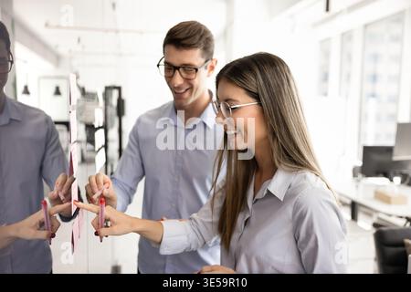 Two young colleagues discussing joint tasks, goals, or creative ideas Stock Photo