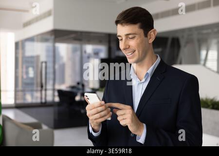 Young businessman using smart phone at workplace Stock Photo