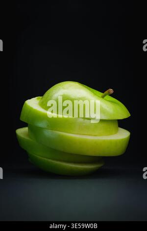 Green apple stacked slices on black background Stock Photo