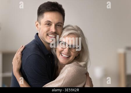 Close up portrait of adult son hugging tightly middle-aged mother Stock Photo