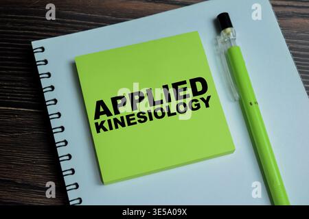 Concept of applied kinesiology write on sticky notes isolated on Wooden Table. For muscle testing, body balance and holistic therapy Stock Photo