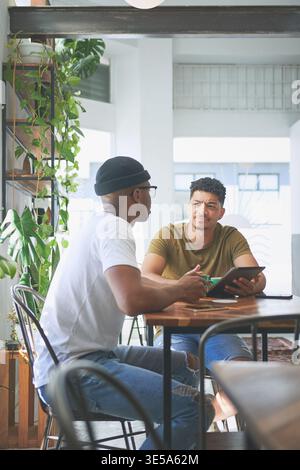 Team, talking and businessmen with tablet in cafe, content creation and planning for project on web. Coffee shop, remote work and people with digital Stock Photo