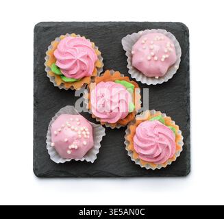 Top view of mini cakes on slate plate isolated on white Stock Photo