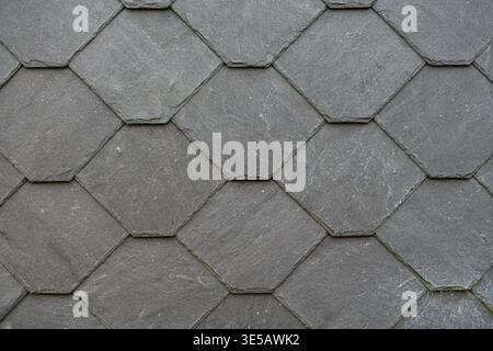 Close up of gray slate roof tiles arranged in a hexagonal pattern. Stock Photo