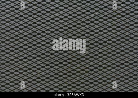 Close up of metal mesh with repeating diamond shaped pattern over a translucent background. Stock Photo