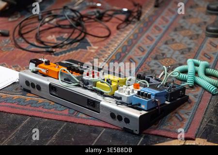 Pedalboard with various guitar effect pedals connected by patch cables, ready for creative sound Stock Photo