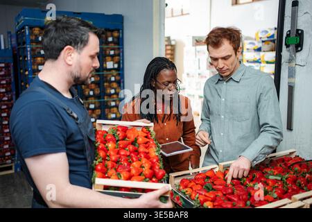 Workers inspecting fresh strawberries for quality control in warehouse Stock Photo
