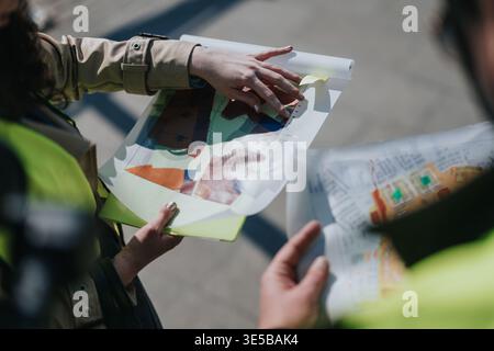 Construction engineers reviewing site plans and maps on a clipboard during outdoor inspection Stock Photo