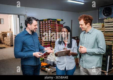 Produce team discussing logistics in cold storage warehouse Stock Photo