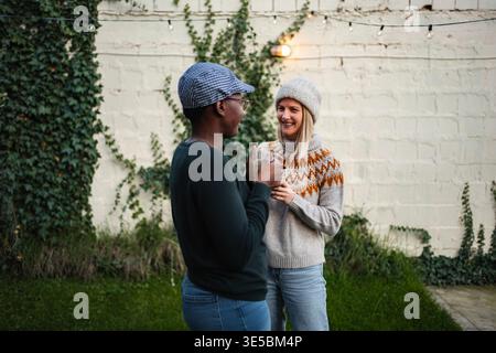 Friends enjoying backyard conversation and coffee together Stock Photo