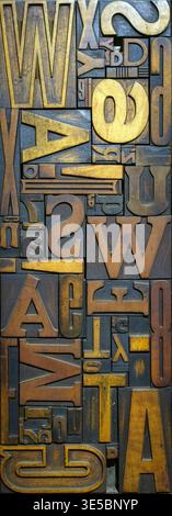 Vintage wooden typesetting letters and blocks for traditional letterpress printing. A close-up background showing old weathered typography stamps with various fonts and characters. High quality photo Stock Photo