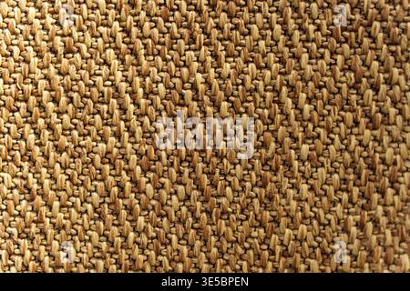 Detailed texture of a modern synthetic carpet with a tight weave pattern. High-angle view of durable textile flooring material in neutral brown and beige shades for office or home. High quality photo Stock Photo