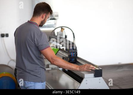 Male engineer setup plasma cutter for work in metalwork workshop. Stock Photo