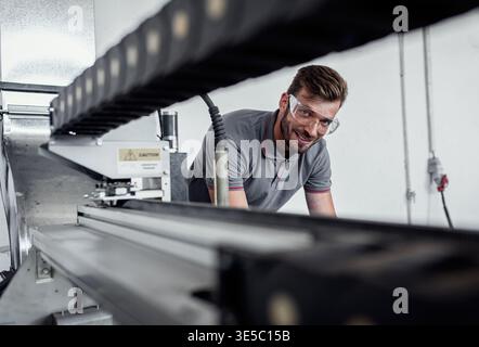Male engineer setup plasma cutter for work in metalwork workshop. Stock Photo