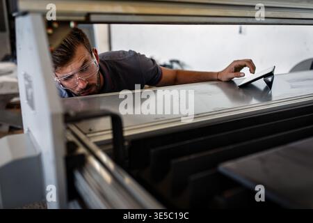 Male engineer setup plasma cutter for work in metalwork workshop. Stock Photo