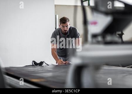 Male engineer setup plasma cutter for work in metalwork workshop. Stock Photo