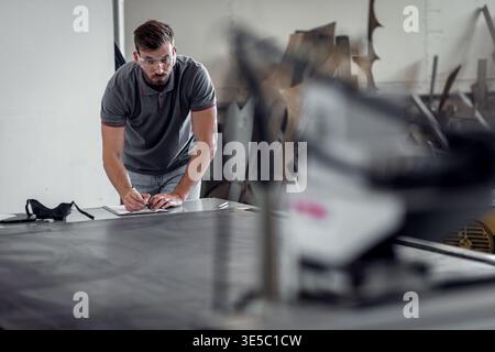 Male engineer setup plasma cutter for work in metalwork workshop. Stock Photo