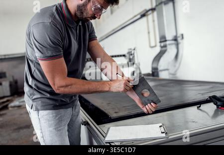 Male engineer setup plasma cutter for work in metalwork workshop. Stock Photo