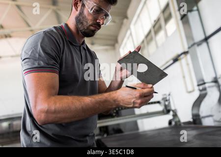 Male engineer setup plasma cutter for work in metalwork workshop. Stock Photo