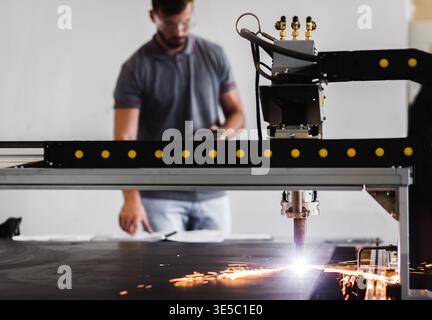 Male engineer setup plasma cutter for work in metalwork workshop. Stock Photo