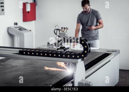 Male engineer setup plasma cutter for work in metalwork workshop. Stock Photo