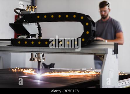 Male engineer setup plasma cutter for work in metalwork workshop. Stock Photo