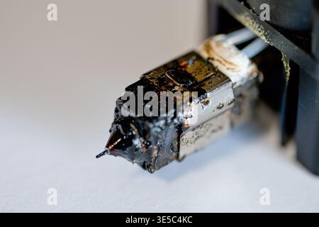 Selective focus on charred and plugged hot end extruder of a 3D filament printer  Stock Photo