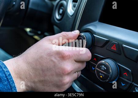 Digital driving experience. User interacts with digital dashboard during modern vehicle journey. Person uses touchscreen technology to navigate while Stock Photo