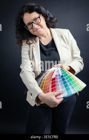 Professional woman holding color fan, presenting options for design work Stock Photo
