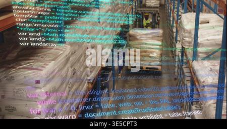 Operating worker driving pallet truck down warehouse aisle, wearing hivis passing pallets with code Stock Photo