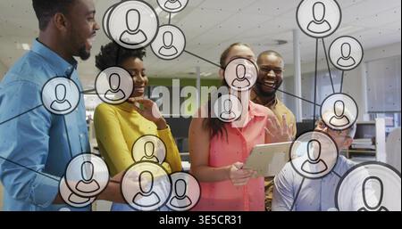 Discussing five colleagues wearing business-casual collaborating on tablet in office, with overlay Stock Photo