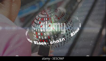 Holding smartphone, woman in light pink top viewing 3D binary globe at station, Block chain Stock Photo