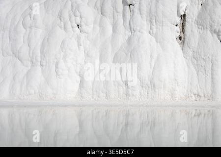 Stunning view of Pamukkale's white travertine formations in Turkey, reflecting on the water's surface. This natural wonder showcases mesmerizing miner Stock Photo
