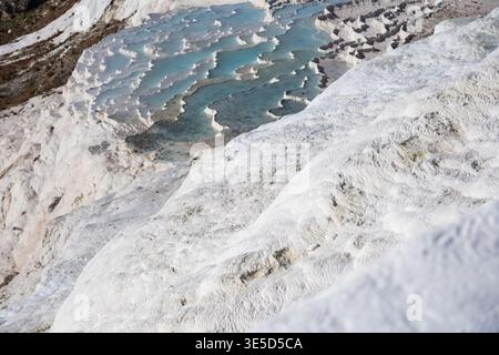 Scenic view of natural travertine terraces in Pamukkale, Turkey, with striking mineral formations and turquoise pools, captured in bright sunlight sho Stock Photo