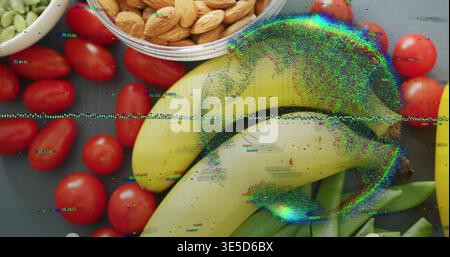 Showing yellow bananas sitting center on dark tray with glass bowl almonds, tomatoes, peas, glitch Stock Photo