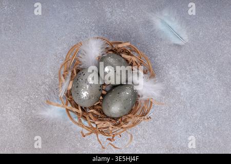 Top view Easter eggs with feathers in wicker nest Stock Photo