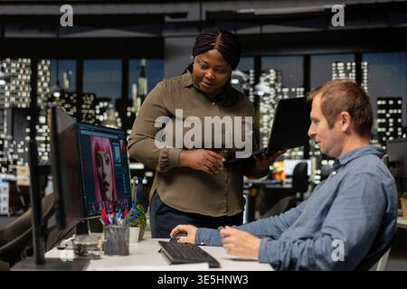 Two photo editors using AI tools and program for retouching and generating content, creating professional images for creative industry. Diverse photographers editing materials, text to image. Stock Photo