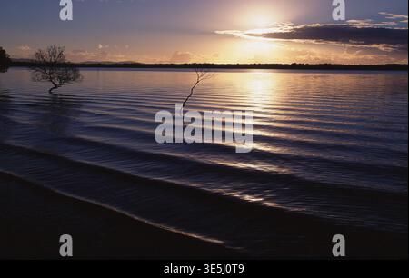 SUNSET OVER LOW TIDE AND THE BEACH ON SOUTH STRADBROKE ISLAND, QUEENSLAND, AUSTRALIA. Stock Photo