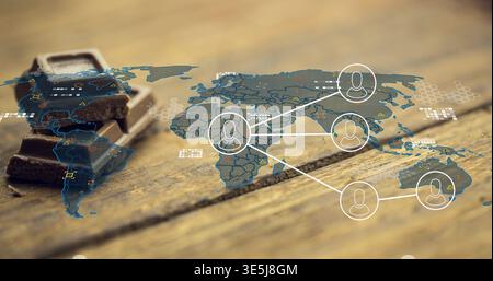 Displaying translucent world map overlay on rustic wood table, with 3 dark chocolate squares, nodes Stock Photo