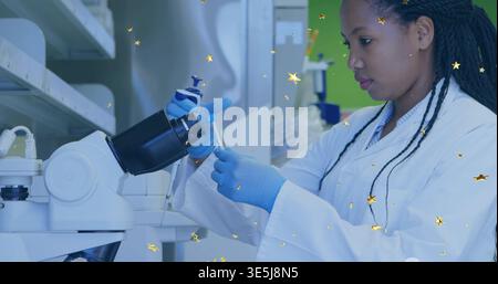 Pipetting scientist in lab coat  and  blue gloves transferring liquid at bench with pipette, copy sp Stock Photo