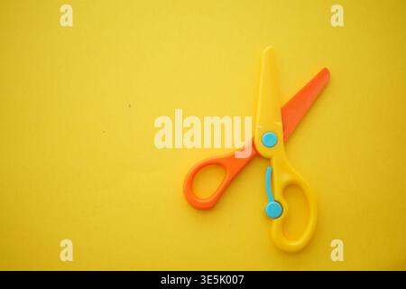 Scissors placed on a yellow background Stock Photo