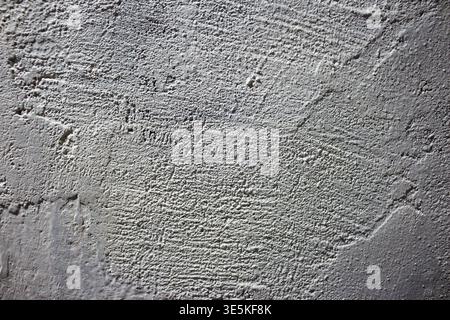 Rough white painted wall texture with strong shadows creating depth and rugged surface patterns Stock Photo