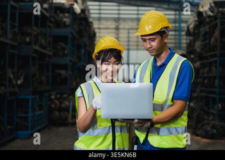 Warehouse workers using laptop for inventory management in industrial storage Stock Photo